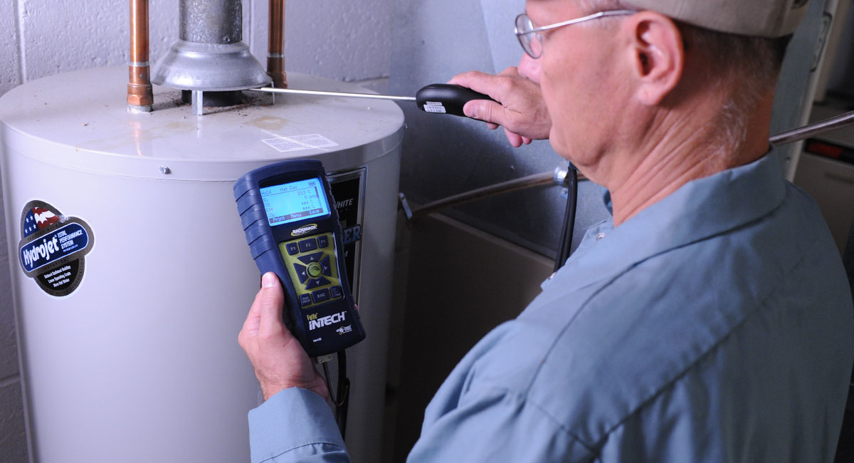 HVAC技术员测试与Intech燃烧分析仪的住宅热水器。